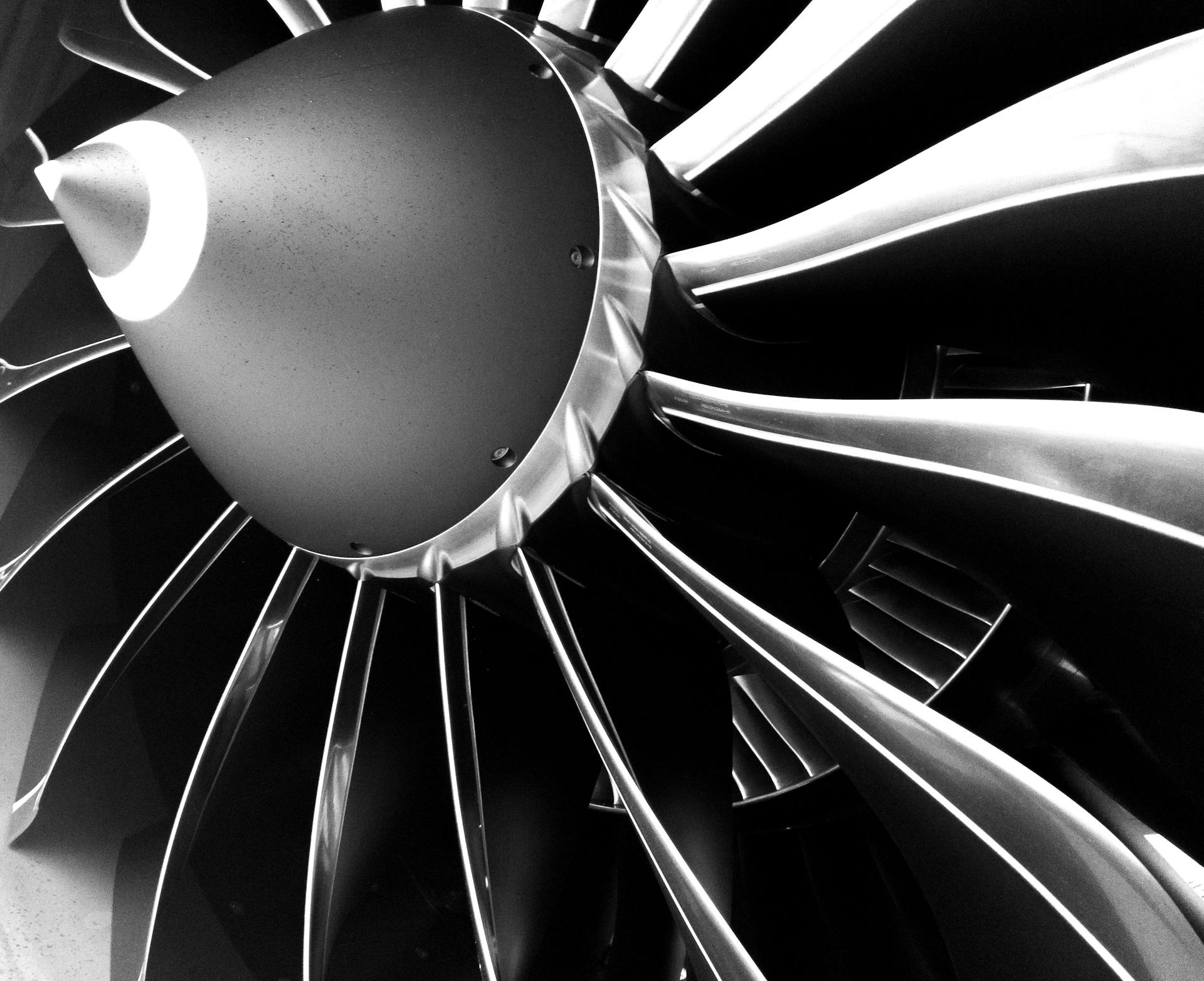 Close up black and white image of a plane's metallic engine blades