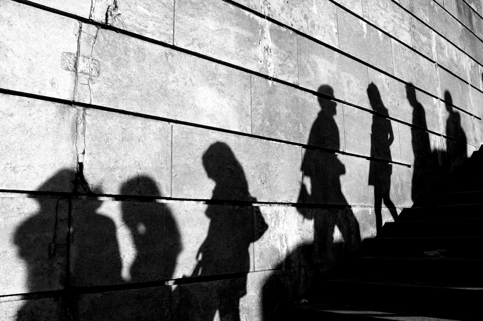 Shadow of people walking up and down an outdoor staircase