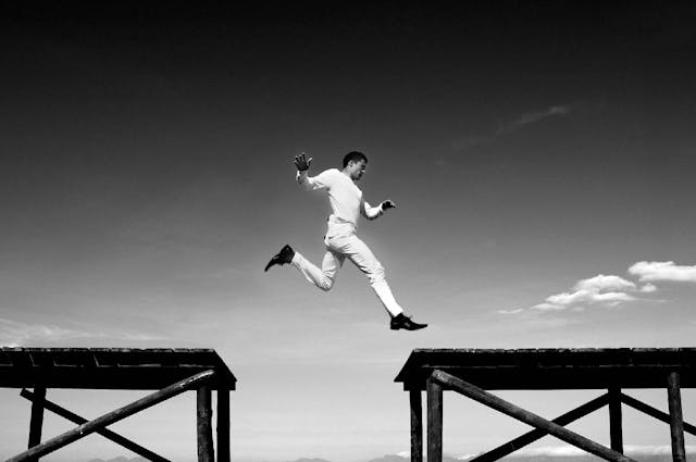 A man jumping between two ledges