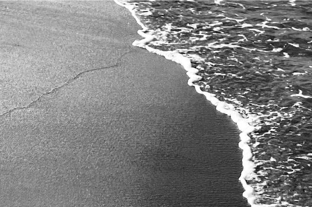 Close up of a wave washing up on a sandy shoreline