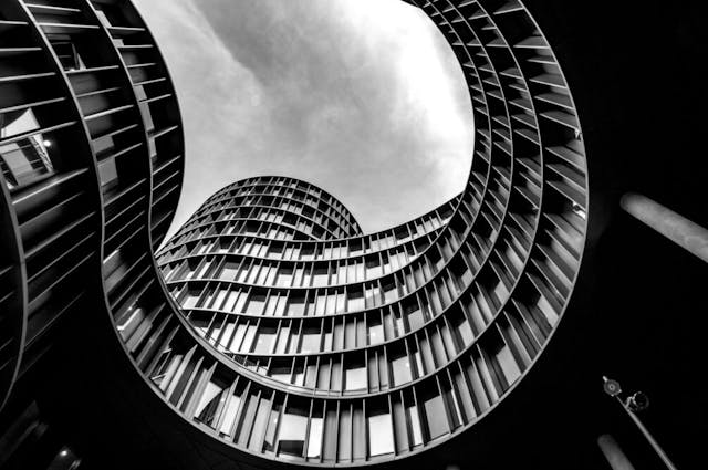 A curved modern building against a cloudy sky