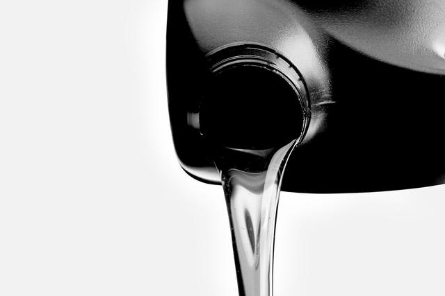 Pouring car oil from bottle isolated on white background